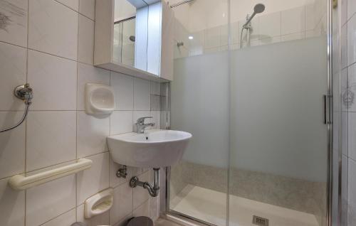 a white bathroom with a sink and a shower at Stunning Apartment In Chiaramonte Gulfi With Wi-fi in Chiaramonte Gulfi