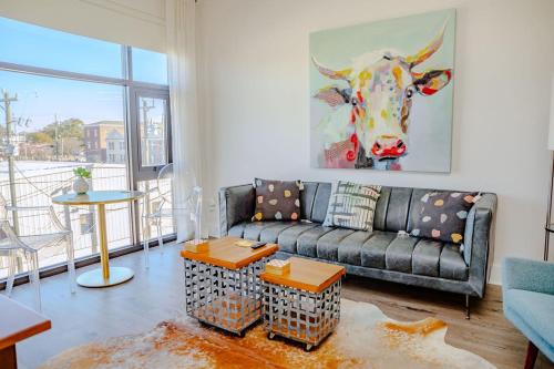 ウィルミントンにあるThe Hive Adjacent 3rd Floor, 301 King & 302 Balconyのソファ付きのリビングルーム、牛の絵が壁に描かれた