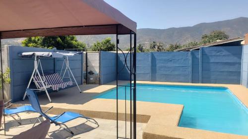 uma piscina com uma cadeira e um guarda-sol em Cabañas #1 "A Pies del Valle" em Limache