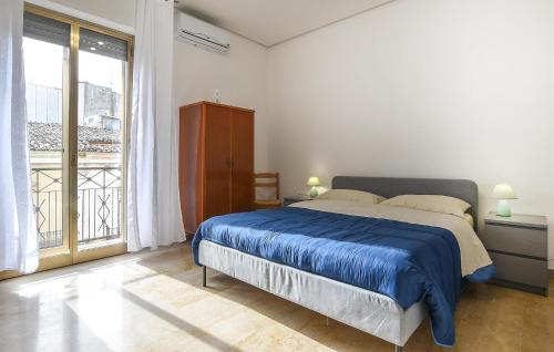 a bedroom with a bed and a large window at Gorgeous Apartment In Chiaramonte Gulfi With Kitchen in Chiaramonte Gulfi