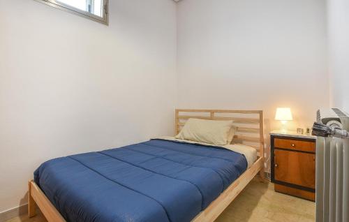 a bedroom with a bed with a blue blanket and a dresser at 2 Bedroom Stunning Apartment In Chiaramonte Gulfi in Chiaramonte Gulfi