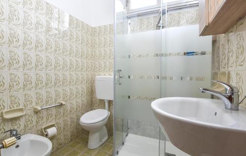 y baño con aseo y lavamanos. en Pet Friendly Apartment In Chiaramonte Gulfi With Wifi en Chiaramonte Gulfi