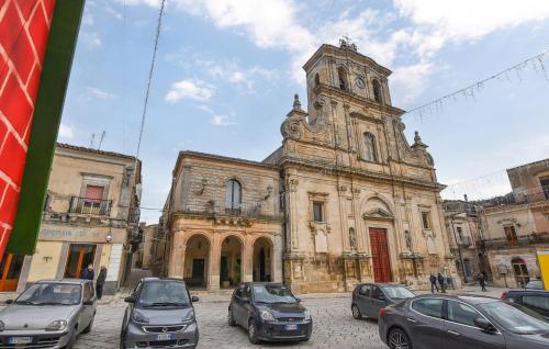 an old building with cars parked in front of it at 2 Bedroom Stunning Apartment In Chiaramonte Gulfi in Chiaramonte Gulfi
