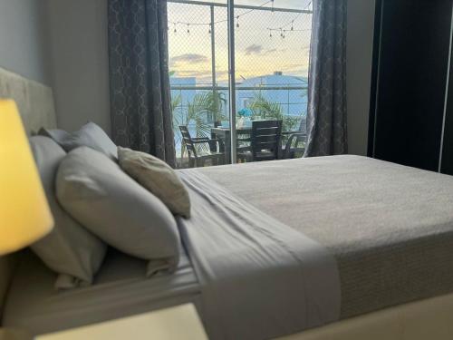 um quarto com uma cama e vista para uma varanda em Beach-Style Pool Villa Paradise em Río Hato
