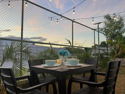 a wooden table with chairs and bowls on it at Beach-Style Pool Villa Paradise in Río Hato