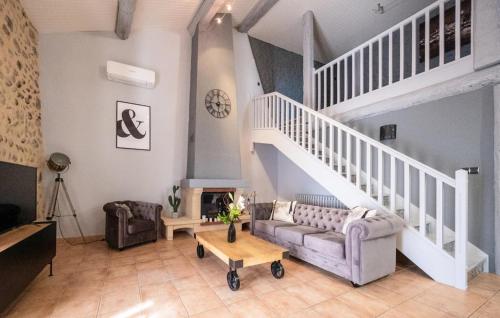 a living room with a couch and a staircase at 2 Bedroom Awesome Home In Les Mées in Les Mées