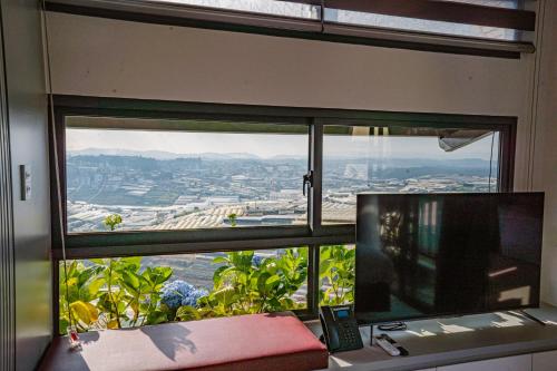 a desk with a computer and a window with a view at Xuân Home in Trai Mat