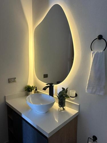a bathroom with a bowl sink and a mirror at Montecielo Hosting in Guatapé