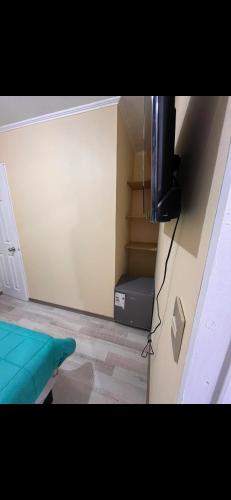 Zimmer mit einem Zimmer mit einem Bett und einem TV in der Unterkunft Habitación con baño privado in Machalí