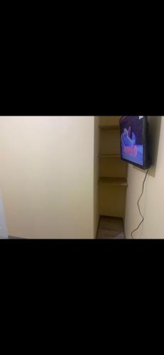 un televisor pequeño sentado en la parte superior de un estante en Habitación con baño privado, en Machalí