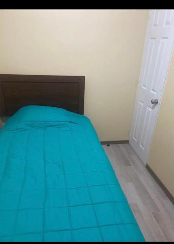 1 dormitorio con 1 cama con colcha azul en Habitación con baño privado, en Machalí