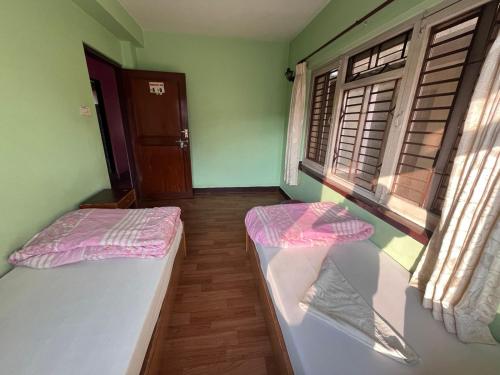 two beds in a room with two windows at Hotel Sweet Dreams thamel kathmandu in Kathmandu