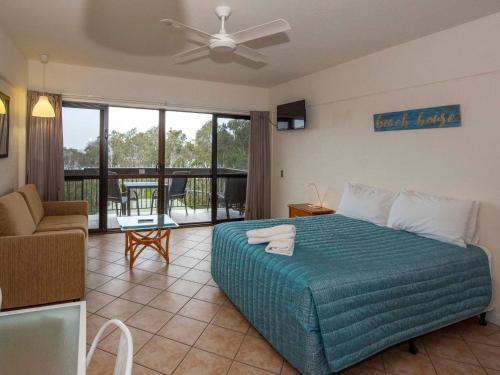 1 dormitorio con 1 cama y sala de estar en Anchorage on Straddie, en Point Lookout