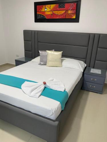 ein Bett mit weißer Bettwäsche und Kissen darauf in der Unterkunft Hotel Don Felipe in Ríohacha