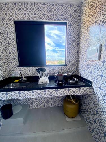 a bathroom with a sink and a window on a wall at Âncora Lofts in Arraial do Cabo