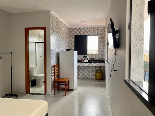 a kitchen with a white refrigerator in a room at Âncora Lofts in Arraial do Cabo