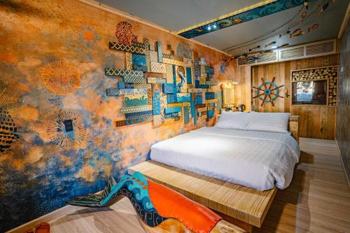 a bedroom with a bed and a wall covered in art at Xuân Home in Trai Mat