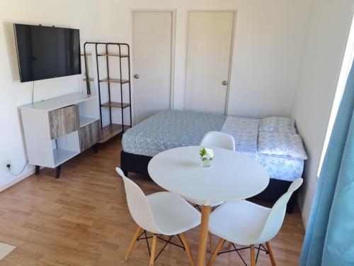 een kleine kamer met een tafel en stoelen en een bed bij Apartamento 2 casa D'Furia in Colonia del Sacramento