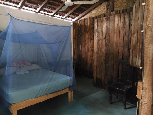 a bedroom with a bed with a mosquito net at Posada Piedra de Fuego in Zipolite