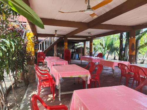a row of red tables and chairs on a patio at Posada Piedra de Fuego in Zipolite