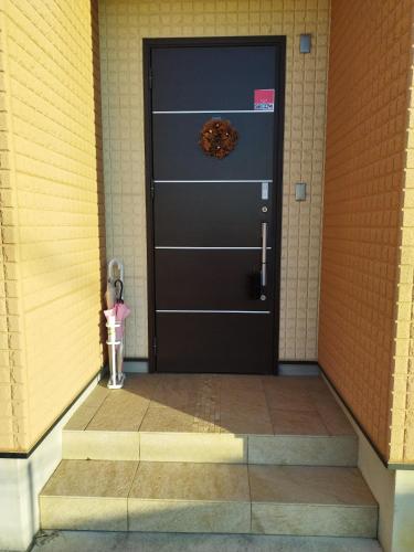 a black door with areath on it in a building at IIIホーム in Shijonawate