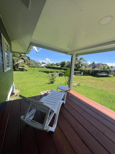 a white lounge chair sitting on the porch of a house at Painapoo - Mirimiri Lodge in Tevaitoa