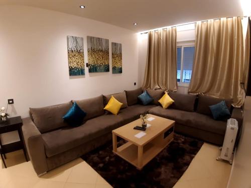 ein Wohnzimmer mit einem Sofa und einem Couchtisch in der Unterkunft Appart happiness family only in Tangier