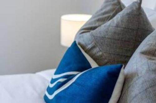 a bed with pillows and a blue and white pillow at Central City Awaits 2 bed 2 bath in Christchurch