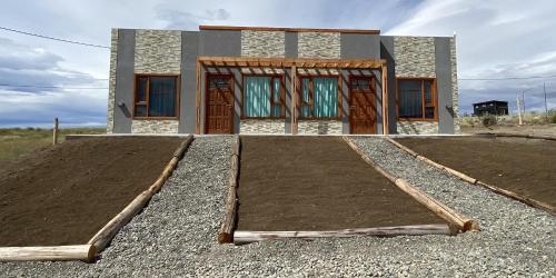 Uma casa está a ser construída com um monte de terra. em Jardines del Calafate em El Calafate