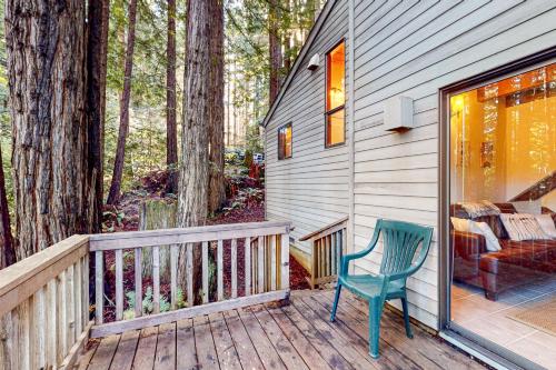 a green chair sitting on a deck next to a house at Deep Woods Hideaway in Annapolis