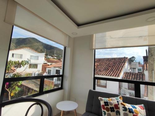 a room with two large windows and a couch at Apartamento 202 in Guatavita