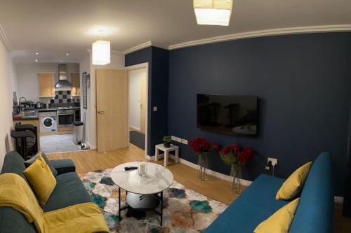 a living room with a blue couch and a table at Entire flat in Ealing in London