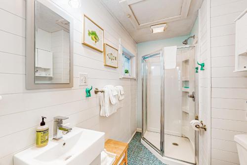ein weißes Bad mit einem Waschbecken und einer Dusche in der Unterkunft Northwoods Oasis in Presque Isle