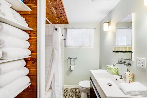 ein Bad mit einem Waschbecken, einem WC und Handtüchern in der Unterkunft Cozy Retreat in Girdwood