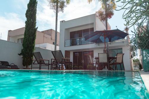 een villa met een zwembad voor een huis bij Casa de Temporada Homer House in Porto Seguro