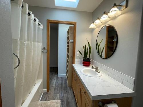 ein Bad mit einem Waschbecken und einem Spiegel in der Unterkunft Modern 3 Bedroom Home in Beaverton in Beaverton