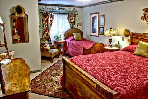 a bedroom with two beds with red comforter at Big Yellow Inn in Cedar City