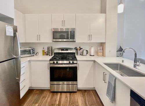 a kitchen with white cabinets and a stainless steel stove at Fremont Experience with Pool/spa in Las Vegas