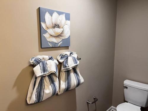 a bathroom with towels on the wall next to a toilet at Unwind in Tranquil Style - Spacious 3-Bed Haven in University Place