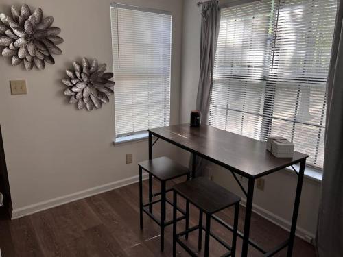 a dining room with a table and two stools at Unwind in Tranquil Style - Spacious 3-Bed Haven in University Place