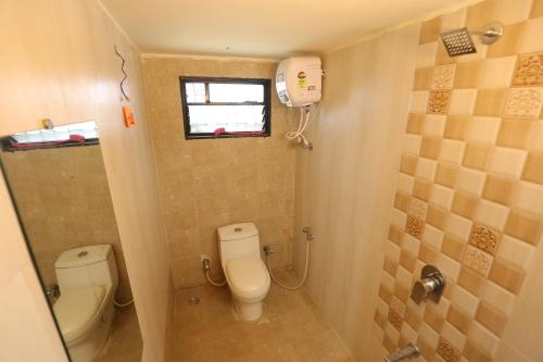 a small bathroom with a toilet and a window at ROHAN HOUSE in Nashik