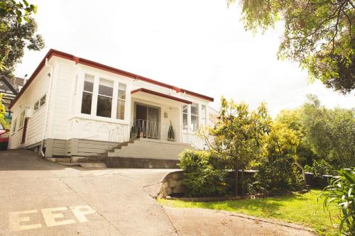 a white house with a porch and a driveway at Hilltop on Milton in Napier