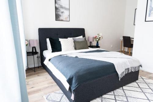a bedroom with a large bed with a blue blanket at Deluxe 2BDRs Home in Spa District Center in Karlovy Vary