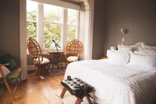 Un dormitorio con una gran cama blanca y una ventana en Hilltop on Milton, en Napier