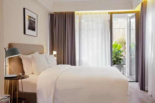 a bedroom with a white bed and a large window at Shenzhen Shekou No.6 Garden Hotel (Sea World) in Shenzhen