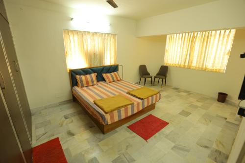 a bedroom with a bed and two chairs in it at ROHAN HOUSE in Nashik