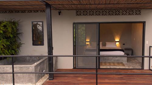 a room with a bed and a balcony at Casa Xue Tayrona - Alma Hotels in Los Naranjos