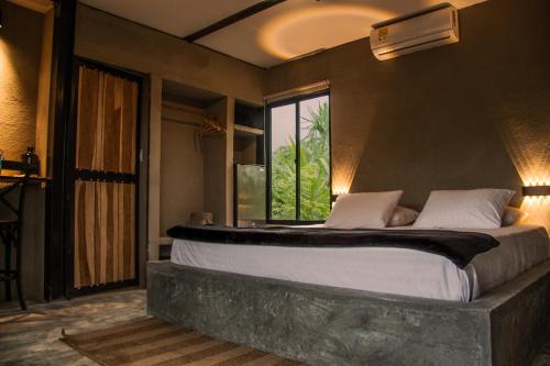 a bedroom with a large bed with a window at Casa Xue Tayrona - Alma Hotels in Los Naranjos