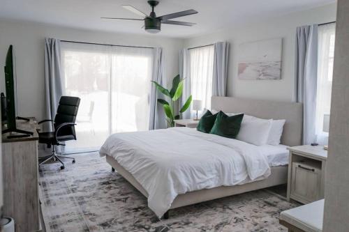 ein weißes Schlafzimmer mit einem Bett und einem Deckenventilator in der Unterkunft Great Location, 10 Mins to Beach, Vero Pool House in Vero Beach