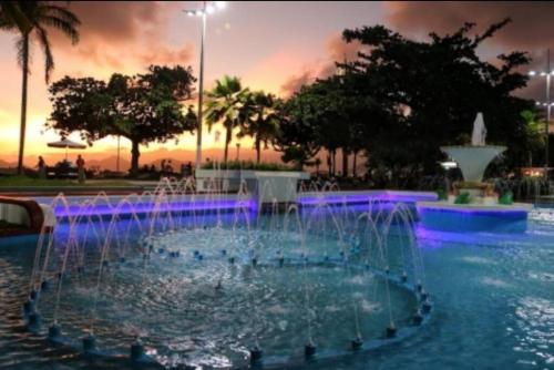 a fountain with purple lights in a park at Excelente acomodação e localização. in Santos